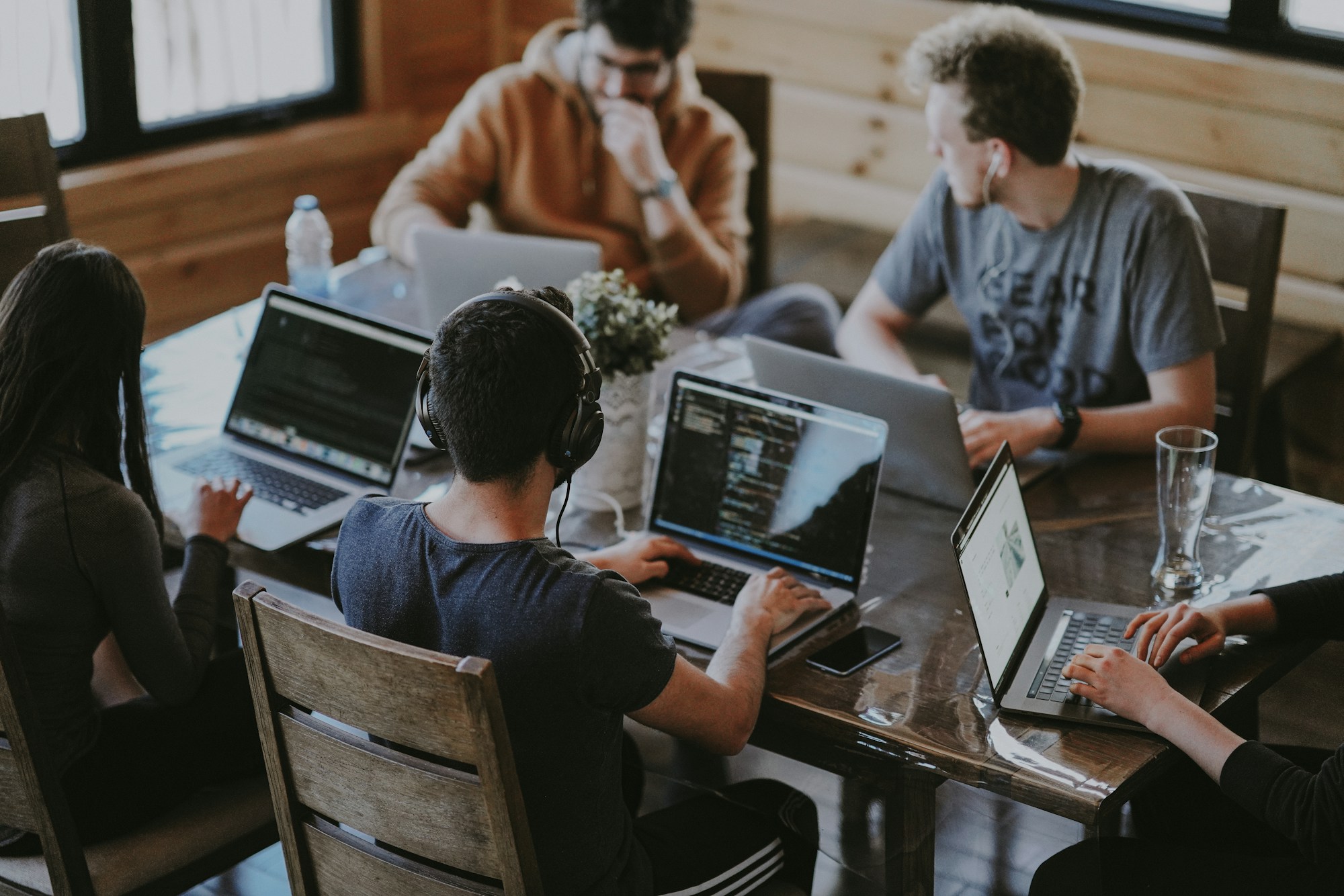 Team collaborating on laptops — AI paired with human engineering
